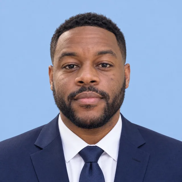 Example of a square headshot: a man in a navy suit and tie on a blue background